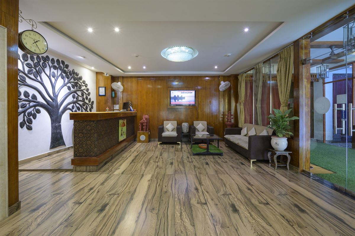 Shri Nilayam Kutir lobby with traditional wood panelling and tree art